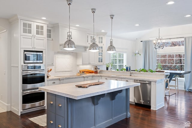 1263 E Chapman Ct, Alpine, UT 84004 - kitchen with appliances with stainless steel finishes, a sink, a peninsula, white cabinetry, and decorative backsplash