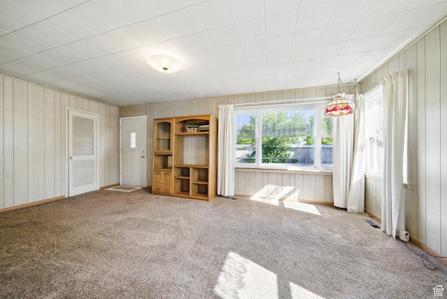 808 E 3685 S, Millcreek, UT 84106 - unfurnished living room with baseboards, wood walls, visible vents, and carpet