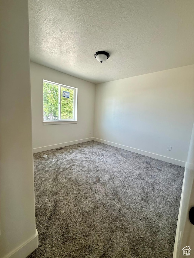 136 W Main St, Fielding, UT 84311 - spare room with a textured ceiling, baseboards, and carpet flooring