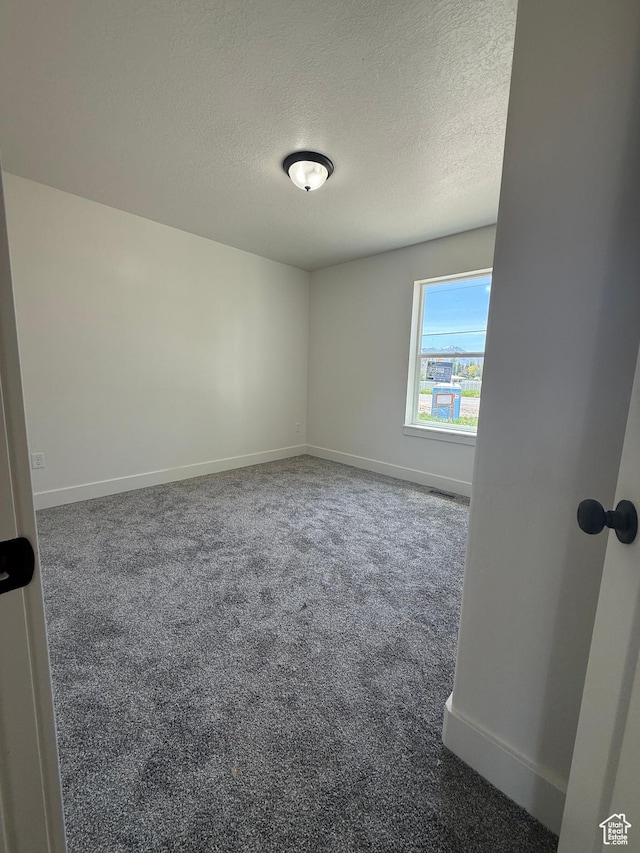 136 W Main St, Fielding, UT 84311 - empty room featuring a textured ceiling, baseboards, and carpet flooring