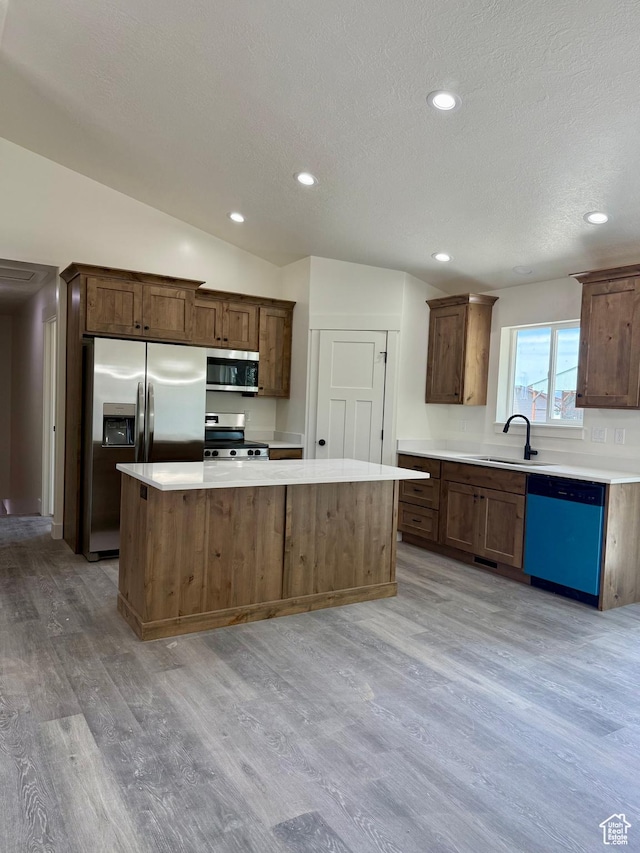 136 W Main St, Fielding, UT 84311 - kitchen with stainless steel appliances, a sink, light wood finished floors, a kitchen island, and light countertops