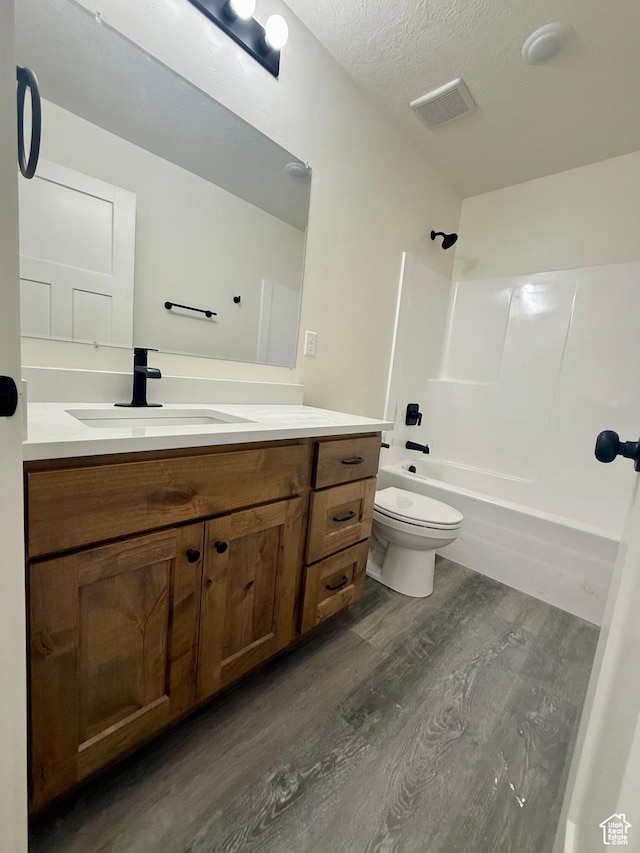 136 W Main St, Fielding, UT 84311 - full bath featuring wood finished floors, toilet, vanity, bathtub / shower combination, and a textured ceiling