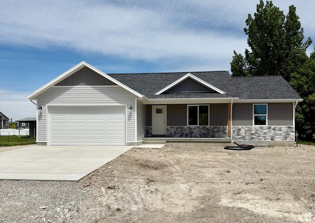 136 W Main St, Fielding, UT 84311 - single story home featuring covered porch, concrete driveway, a garage, stone siding, and roof with shingles