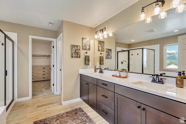 full bath featuring visible vents, wood finished floors, a sink, and a stall shower