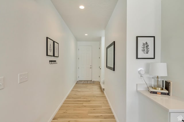 hall with recessed lighting, light wood-type flooring, and baseboards