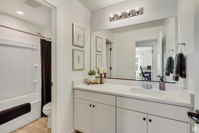 bathroom featuring wood finished floors, vanity, shower / bath combination with curtain, toilet, and visible vents