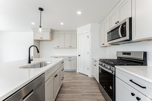 3677 W 950 N Unit 219, Lehi, UT 84043 - kitchen featuring stainless steel appliances, recessed lighting, light wood finished floors, decorative light fixtures, and light stone countertops