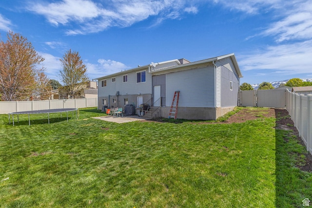 1282 S 875 W, Woods Cross, UT 84087 - back of property featuring a fenced backyard, entry steps, a yard, a patio, and a trampoline