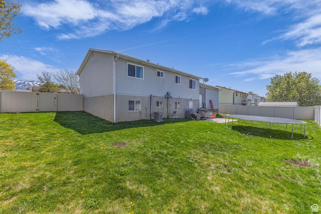 1282 S 875 W, Woods Cross, UT 84087 - rear view of property featuring a fenced backyard, cooling unit, a gate, a trampoline, and a lawn