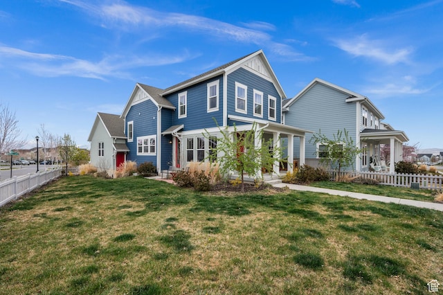 traditional home featuring fence, a front yard, and covered porch