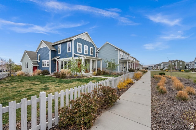 view of front of home featuring a front lawn, fence private yard, and a residential view