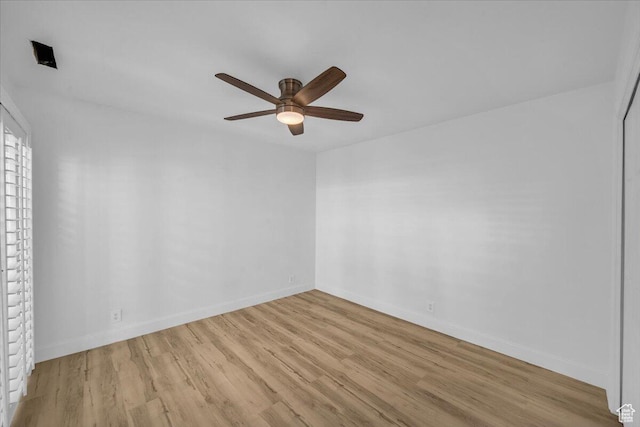 empty room featuring ceiling fan, baseboards, and wood finished floors