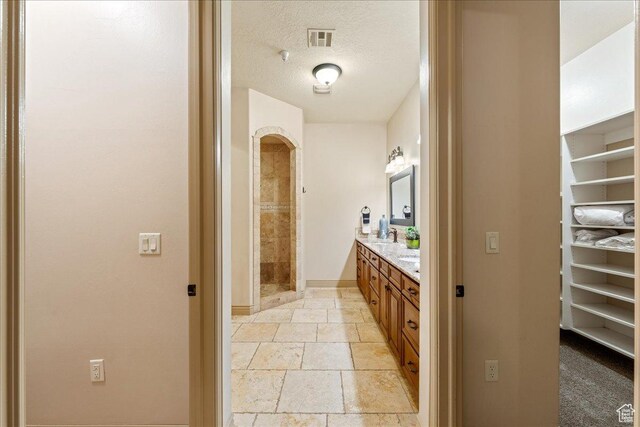 188 N 6680 W Unit 4, Hurricane, UT 84737 - full bath with a shower stall, double vanity, visible vents, stone tile flooring, and a textured ceiling