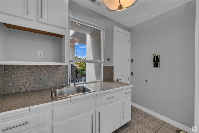 kitchen featuring a sink, light tile patterned flooring, tasteful backsplash, white cabinetry, and open shelves