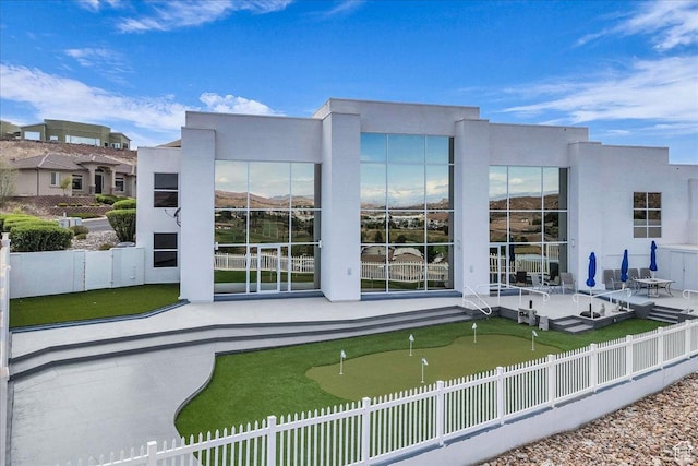 rear view of property with fence and a patio