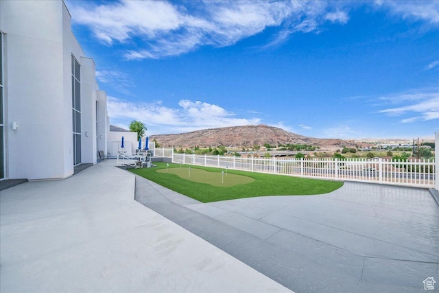 view of patio featuring fence and a mountain view