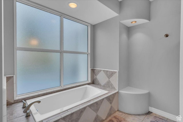 bathroom featuring a bath, plenty of natural light, and tile patterned flooring