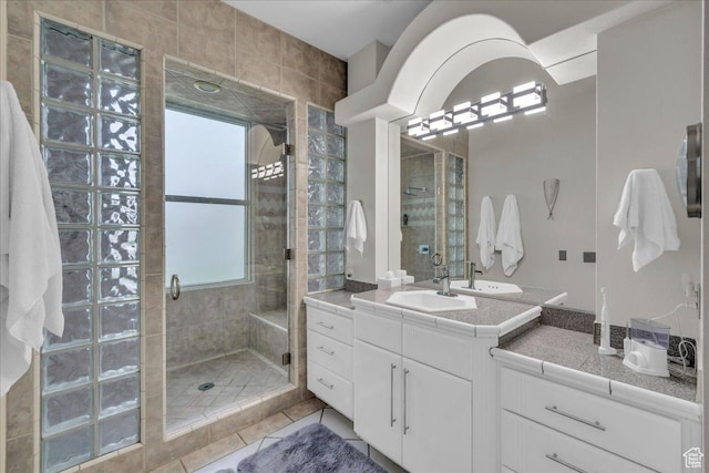 full bath with vanity, tile patterned flooring, and a stall shower