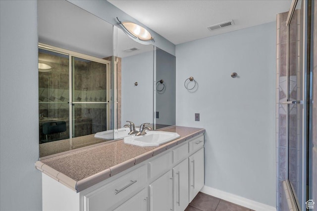 bathroom with visible vents, tile patterned flooring, vanity, and a shower with door