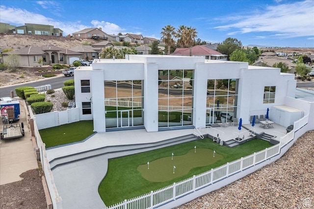 back of house with a fenced backyard, a residential view, and a patio