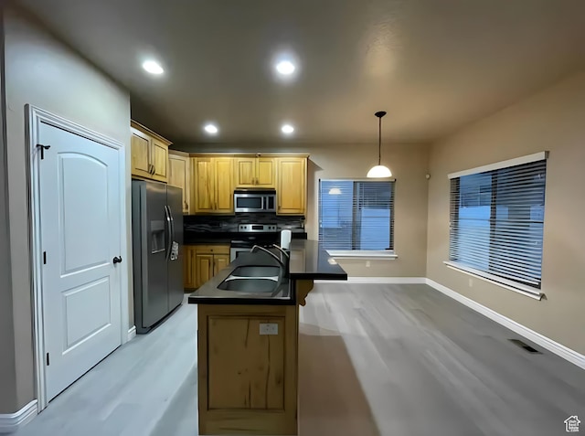 kitchen featuring a sink, dark countertops, baseboards, backsplash, and appliances with stainless steel finishes