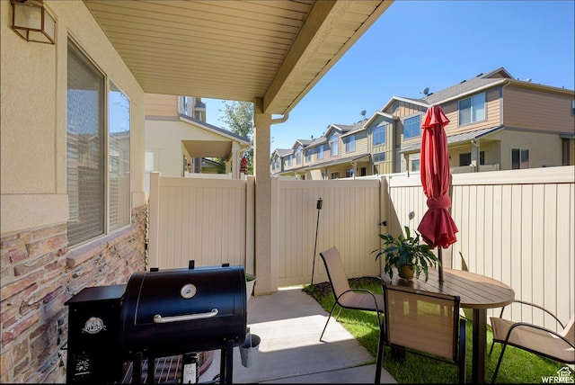 view of patio / terrace with fence, a residential view, and a grill
