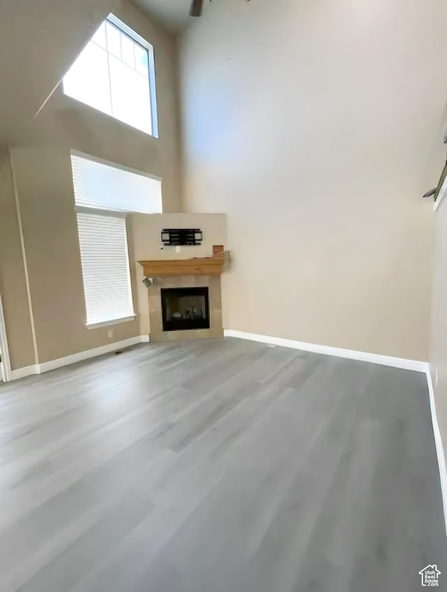 unfurnished living room featuring wood finished floors, baseboards, and a fireplace