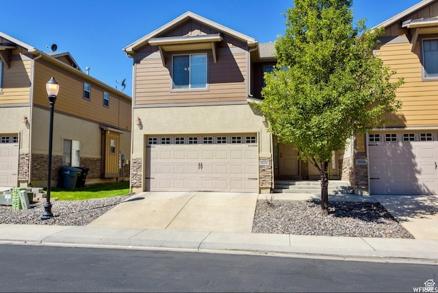view of front of property with stucco siding, driveway, stone siding, and a garage
