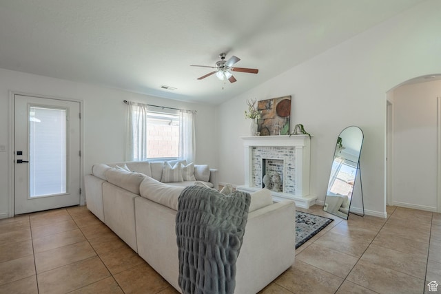 1024 Painted Cloud Pl, Washington, UT 84780 - living room featuring visible vents, light tile patterned floors, arched walkways, a fireplace, and ceiling fan