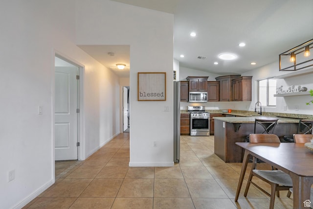 1024 Painted Cloud Pl, Washington, UT 84780 - kitchen featuring light tile patterned flooring, stainless steel appliances, a peninsula, lofted ceiling, and visible vents