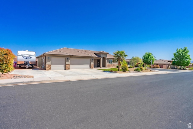 1024 Painted Cloud Pl, Washington, UT 84780 - ranch-style home with concrete driveway, a tile roof, stone siding, and a garage
