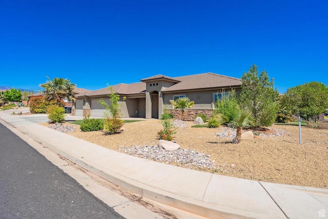 1024 Painted Cloud Pl, Washington, UT 84780 - view of front of house with a tiled roof, stucco siding, driveway, stone siding, and a garage