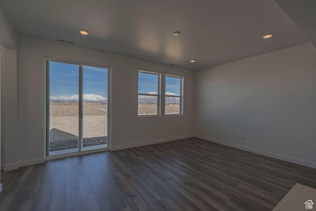 spare room featuring baseboards, dark wood-style flooring, and recessed lighting