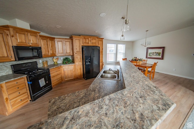 163 Eagle St, Eureka, UT 84628 - kitchen featuring black appliances, backsplash, a sink, and light wood-type flooring