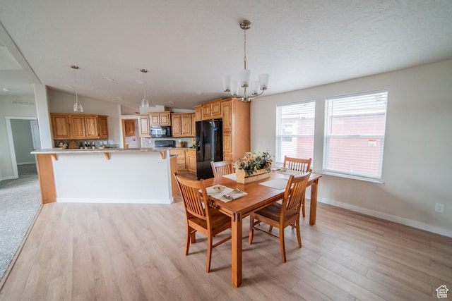 163 Eagle St, Eureka, UT 84628 - dining area featuring lofted ceiling, light wood-style flooring, baseboards, and a chandelier