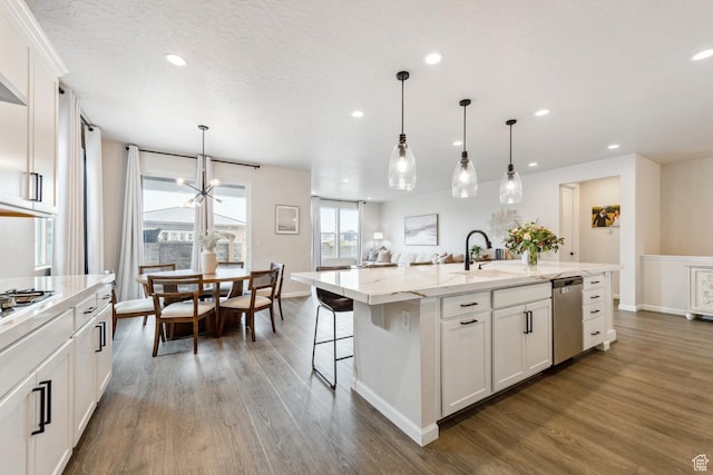 kitchen with white cabinets, a center island with sink, recessed lighting, dark wood-type flooring, and appliances with stainless steel finishes