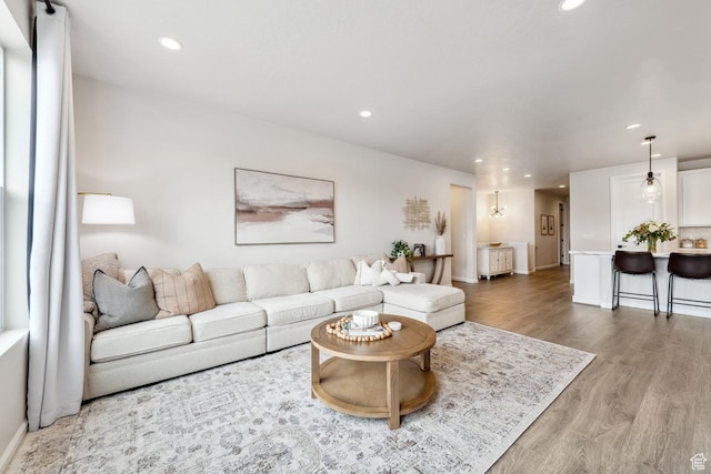 living room featuring baseboards, wood finished floors, and recessed lighting