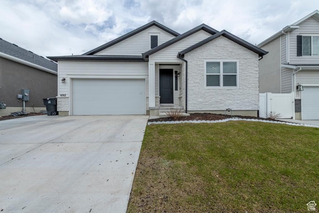 single story home featuring a garage, concrete driveway, stone siding, fence, and a front yard