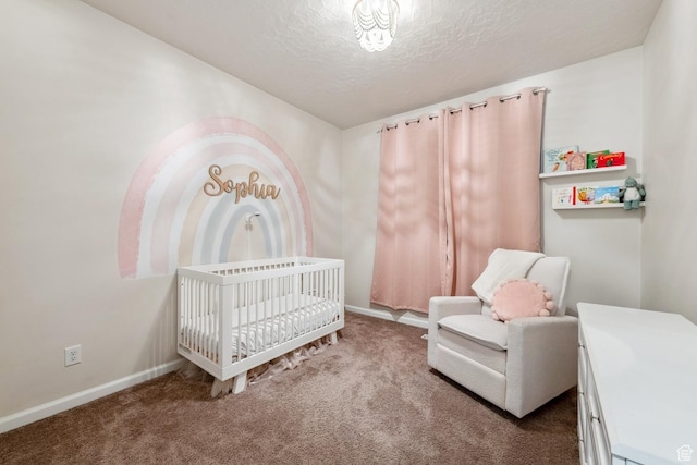 carpeted bedroom featuring baseboards, a crib, and a textured ceiling