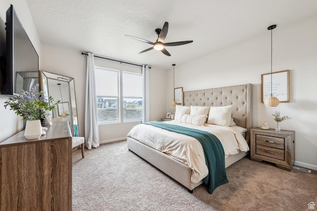 carpeted bedroom with baseboards, a ceiling fan, and visible vents