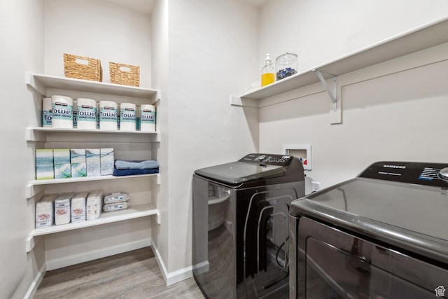 laundry area with independent washer and dryer, wood finished floors, baseboards, and laundry area