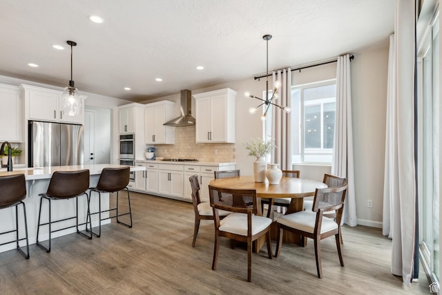 dining area featuring recessed lighting, wood finished floors, baseboards, and an inviting chandelier