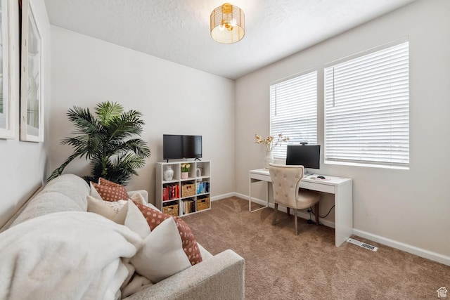 carpeted office featuring baseboards and visible vents