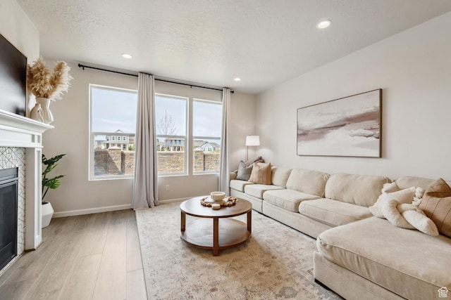 living room with a fireplace, recessed lighting, and light wood-type flooring