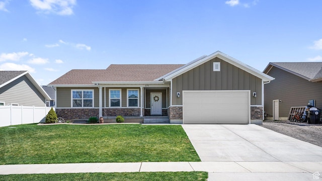 craftsman-style house with a garage, concrete driveway, stone siding, board and batten siding, and a front yard