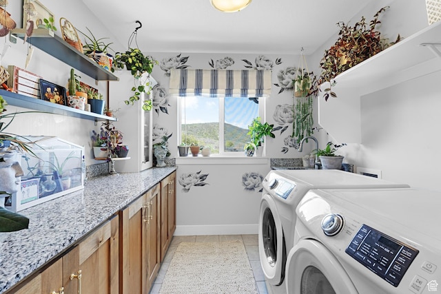 86 Elk Ridge Dr W, Elk Ridge, UT 84651 - laundry area featuring washing machine and dryer, cabinet space, light tile patterned flooring, and baseboards