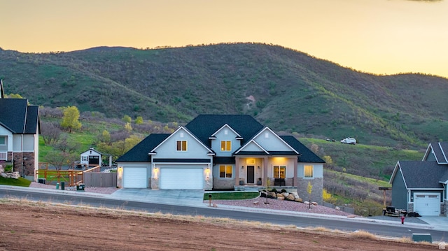86 Elk Ridge Dr W, Elk Ridge, UT 84651 - view of front of property with a mountain view, concrete driveway, stone siding, and an attached garage