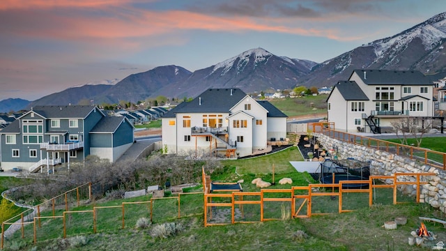 86 Elk Ridge Dr W, Elk Ridge, UT 84651 - back of house at dusk with a mountain view, stairs, a residential view, a fenced backyard, and stucco siding