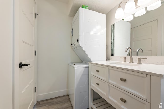 285 W Olympic Ln, Elk Ridge, UT 84651 - washroom featuring a sink, stacked washer / dryer, light wood-style flooring, baseboards, and laundry area
