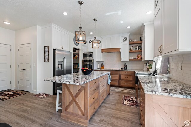 285 W Olympic Ln, Elk Ridge, UT 84651 - kitchen with a center island, light wood-style flooring, a sink, open shelves, and appliances with stainless steel finishes